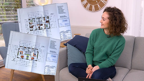 Eine Frau schaut sich Pläne zu Strom- und Erdgasanschlüssen an.