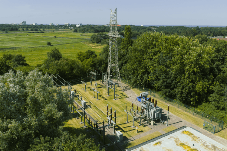 Umspannanlage mit Strommast und elektrischen Betriebsmitteln aus der Vogelperspektive.