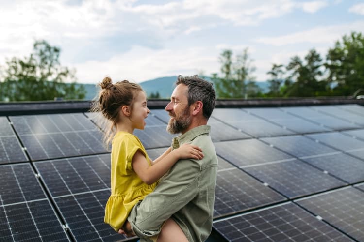Ein Vater und Kind stehen vor einer PV-Anlage