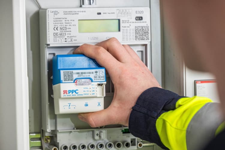 Ein EWE-NETZ.Mitarbeiter bringt einen Smart Meter an