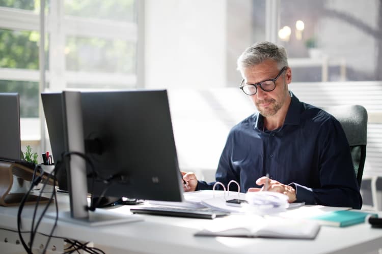 Mann arbeitet im Büro an seinem Computer